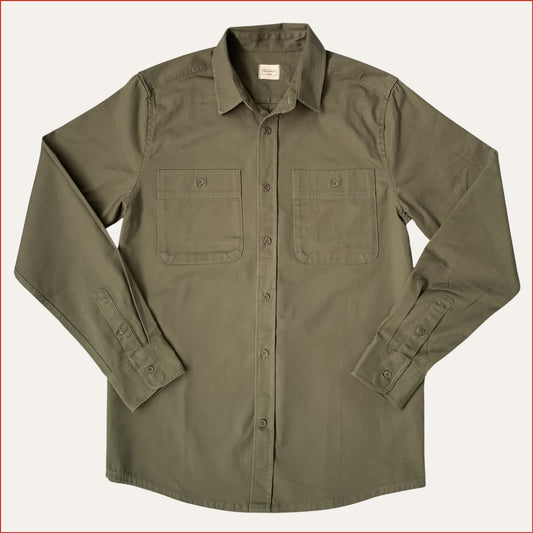 Flat lay image of a khaki cotton drill shirt with two front pockets on a white background. minimalist and understated design casual menswear shoreditch and hale