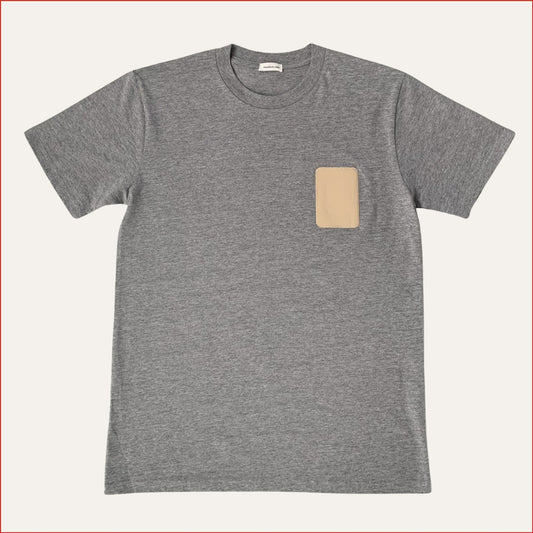 Flay lay photo of a Gray t-shirt with a beige patch on a white background minimalist and understated design by shoreditch and hale
