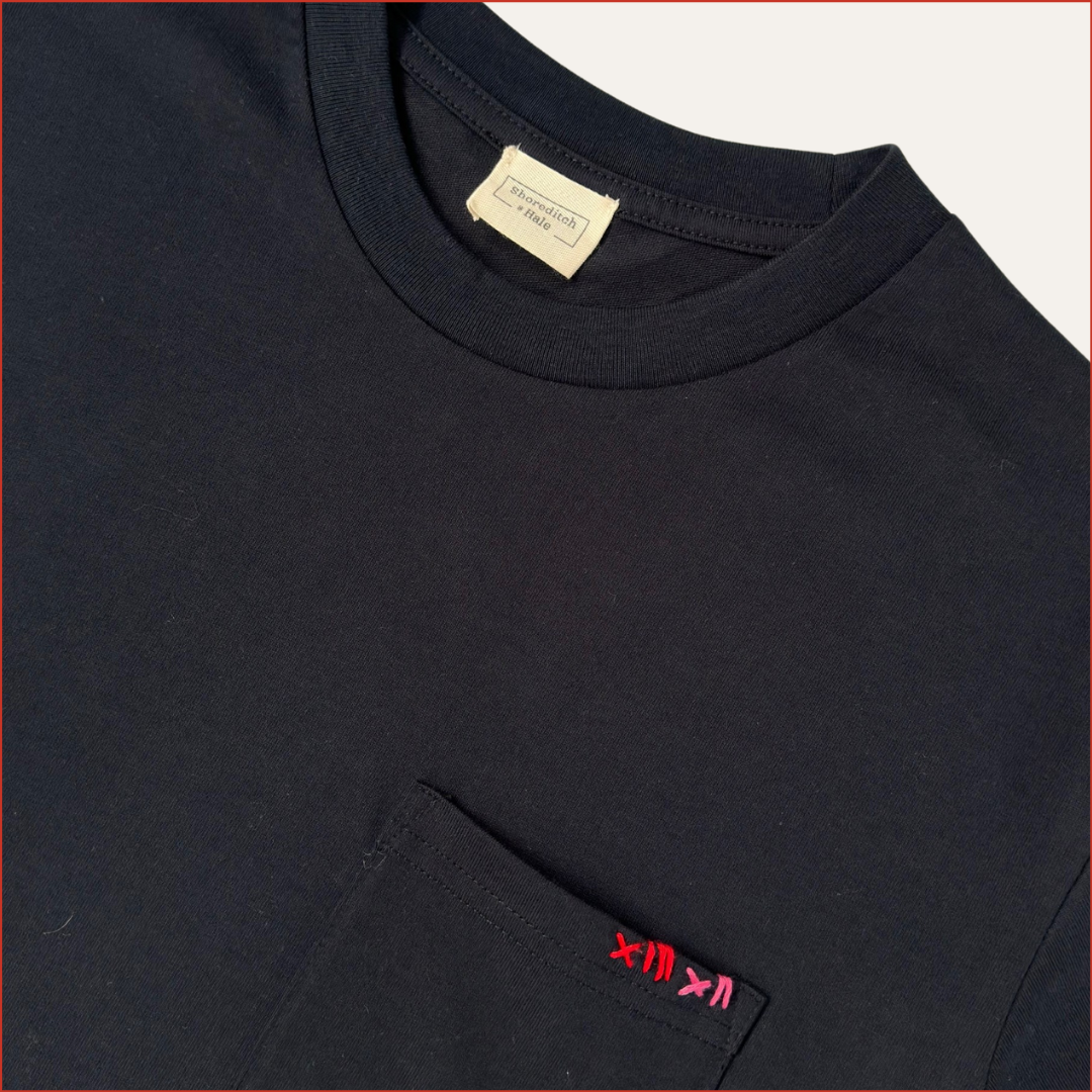 close up image of a men's soft cotton navy pocket tshirt with contrast red stitching on the chest. Minimalist and understated design by shoreditch and hale.
