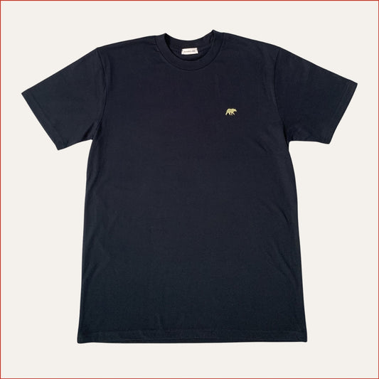 flat lay image of a navy t-shirt with a small pastel yellow bear logo on a white background. Minimalist and understated design by shoreditch and hale