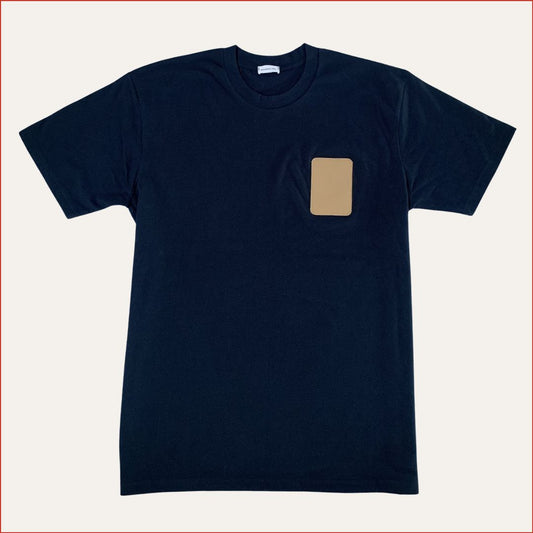 Navy t-shirt with a beige patch on a white background. Minimalist and understated design by shoreditch and hale.