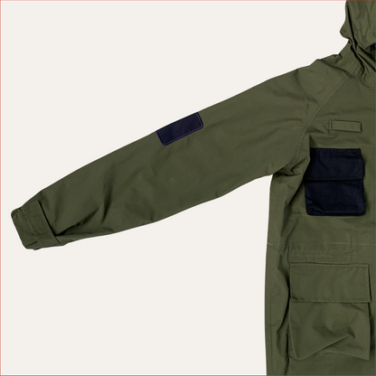 Flat lay photo of a Green Parka jacket by Shoreditch and Hale with navy patches on a white background