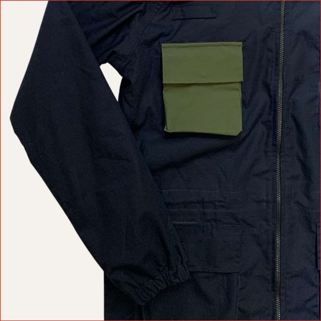 Close up photo of a Navy jacket with a green pocket on a white background minimalist design by shoreditch and hale