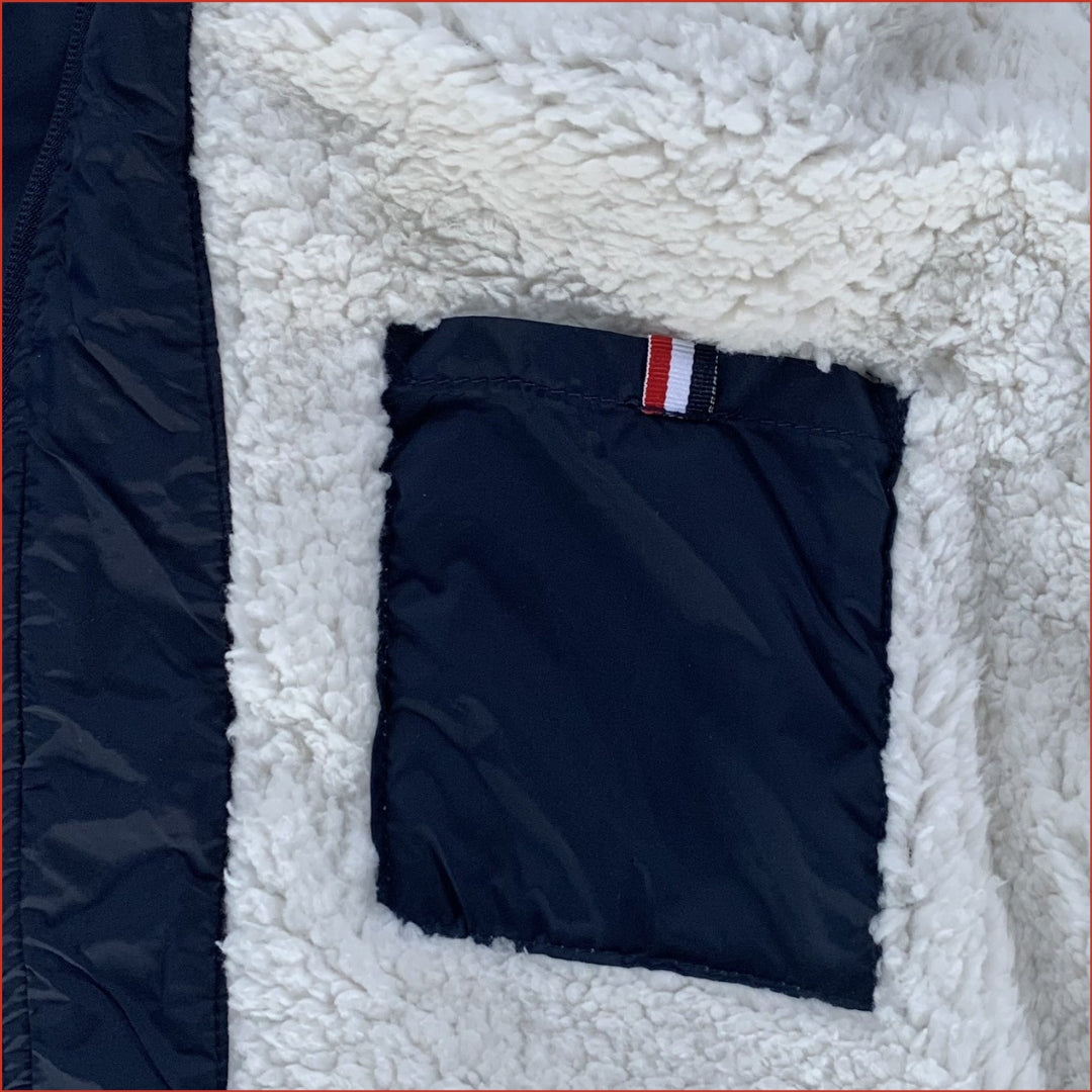 Navy blue parka with white sherpa lining and an inner pocket