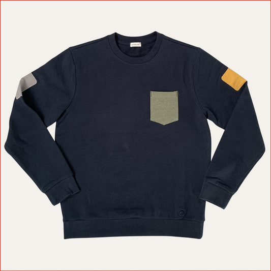 Flat lay image of a men's Navy blue sweatshirt with a pocket and colored arm patches on a light gray background. Designed by Shoreditch and Hale