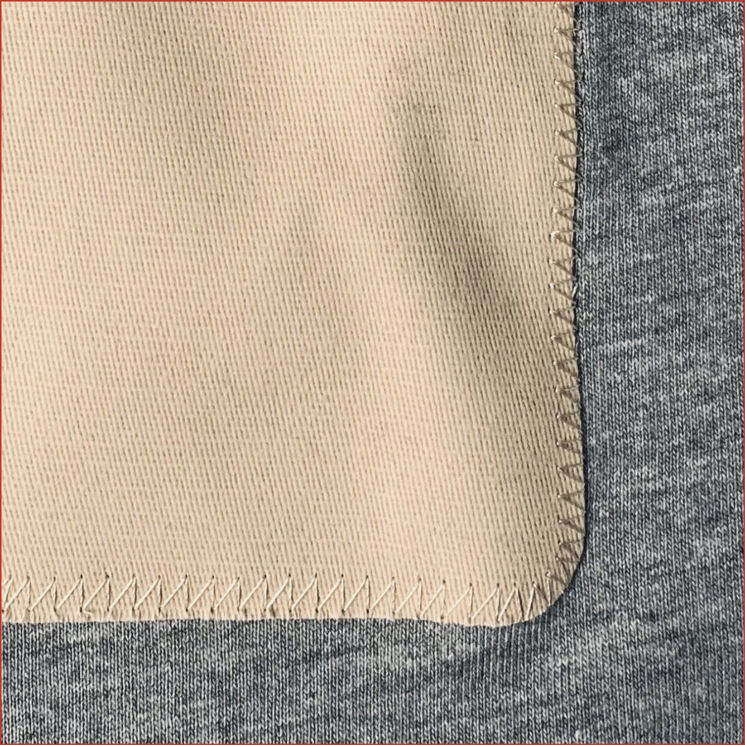 Close up photo of a Gray t-shirt with a beige patch minimalist and understated design by shoreditch and hale