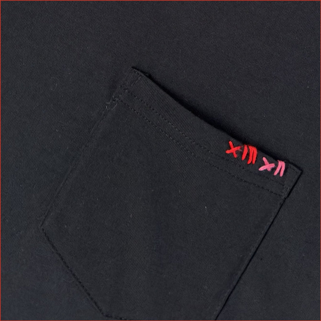 close up image of a men's soft cotton navy pocket tshirt with contrast red stitching on the chest. Minimalist and understated design by shoreditch and hale.