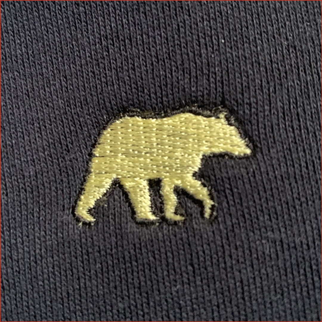Embroidered bear design on a dark fabric background